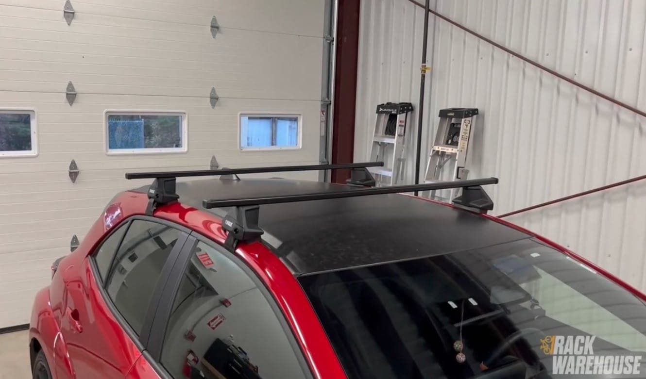 Thule Evo Clamp system with SquareBars installed on a red hatchback